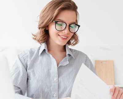 Frau mit Brille prüft Unterlagen